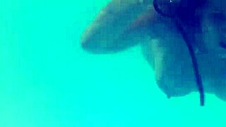 melissa the mermaid swims in the pool with brown eyes and tattoo