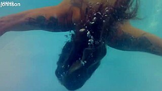 melissa the mermaid swims in the pool with brown eyes and tattoo