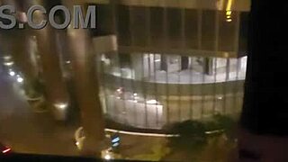 Petite babe masturbates in public by hotel window for thrill