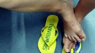candid brazilian girl playing with flip flops in public