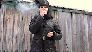 Brunette milf smokes cigarette while fingering her hairy pussy to orgasm outdoors.