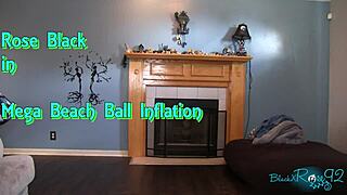 Mega beach ball gets inflated on the beach with black brunette in socks.